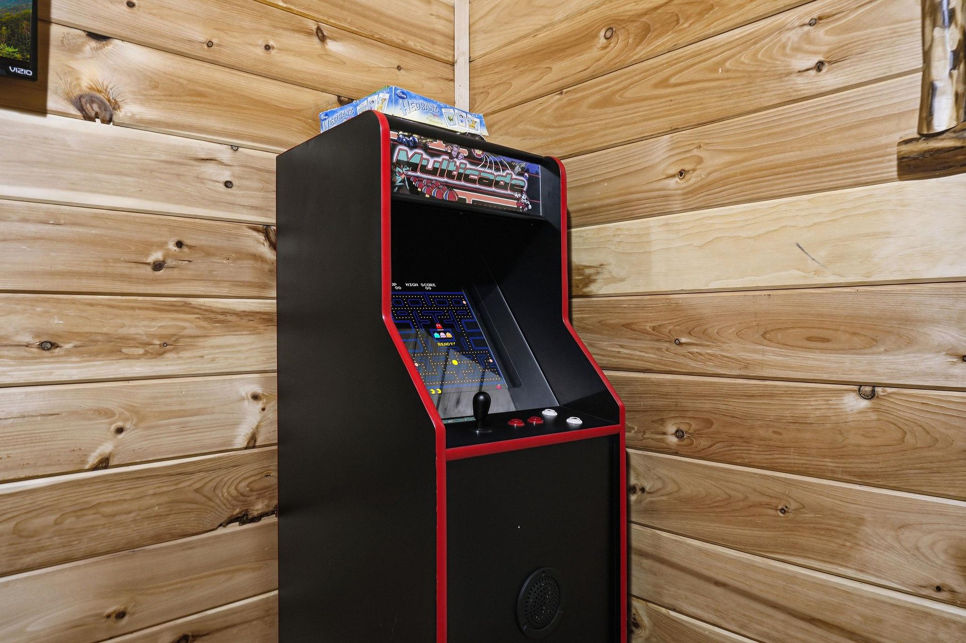 Challenge your friends to classic arcade games in this cozy game room with authentic retro charm and warm wood surroundings.