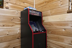 Challenge your friends to classic arcade games in this cozy game room with authentic retro charm and warm wood surroundings.