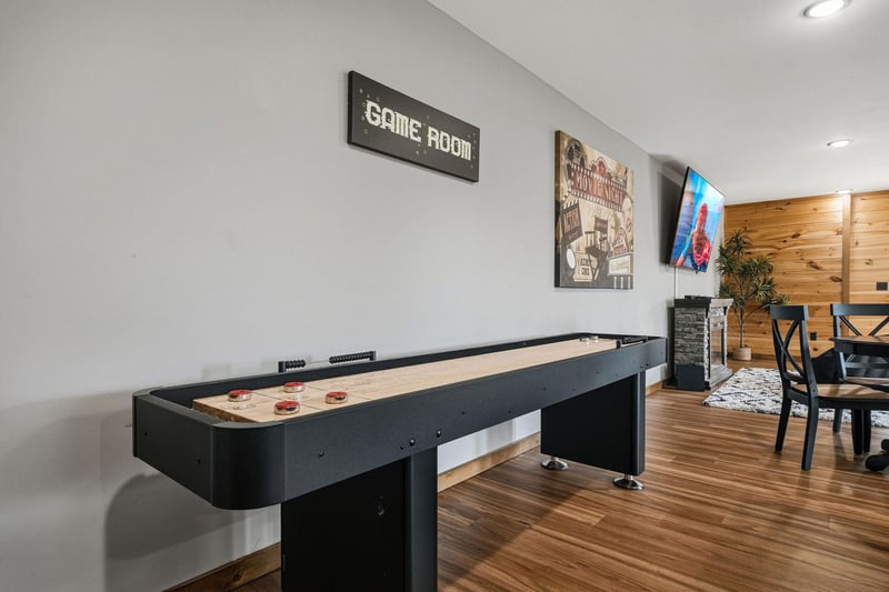 Challenge your friends to a game of shuffleboard in this stylish game room, designed for fun and friendly competition.