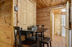 Step inside your cozy cabin retreat, where warm wood wraps around you and a welcoming dining nook awaits your morning coffee and evening meals.
