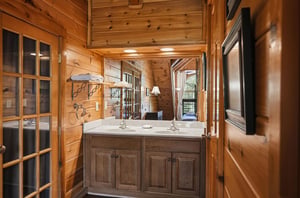 Step into your rustic bathroom where warm wood surrounds dual sinks with marble countertops—perfect for morning routines together.