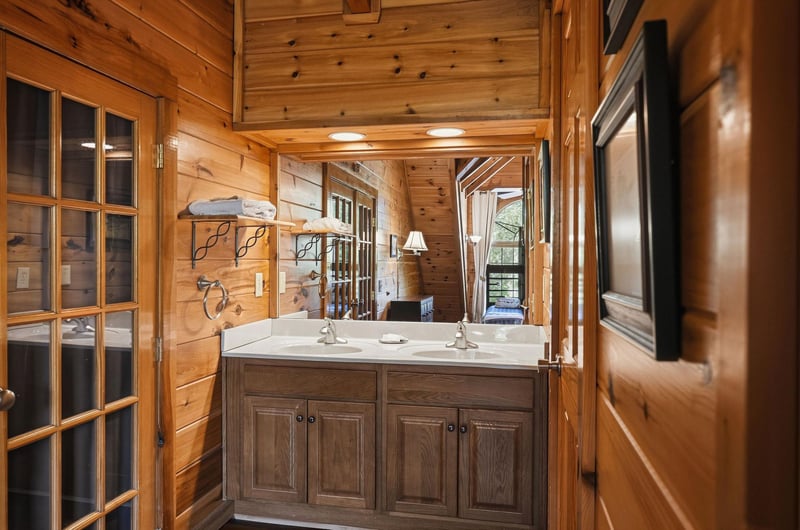 Step into your rustic bathroom where warm wood surrounds dual sinks with marble countertops—perfect for morning routines together.