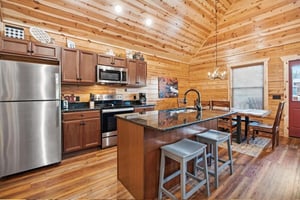 Your rustic kitchen blends modern convenience with cozy cabin charm, featuring granite counters and warm wood throughout.