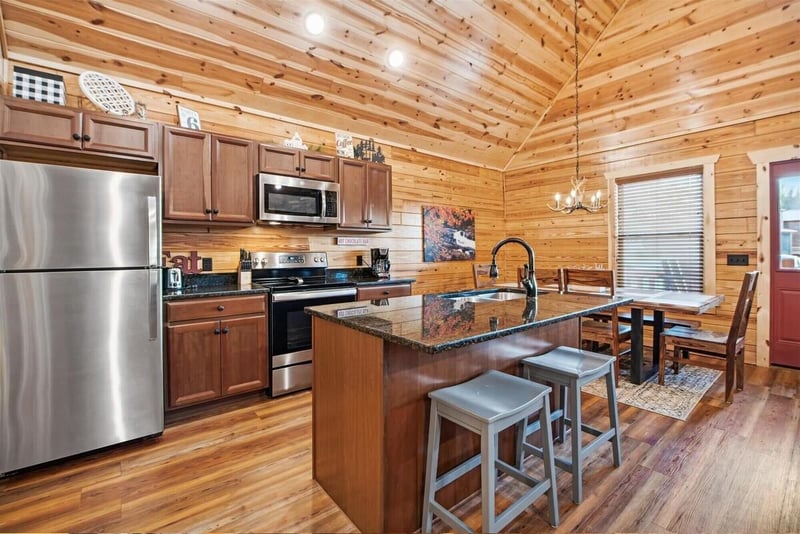Your rustic kitchen blends modern convenience with cozy cabin charm, featuring granite counters and warm wood throughout.