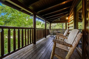 Unwind on your private covered deck with handcrafted log chairs, surrounded by lush forest views that create the perfect mountain retreat escape.