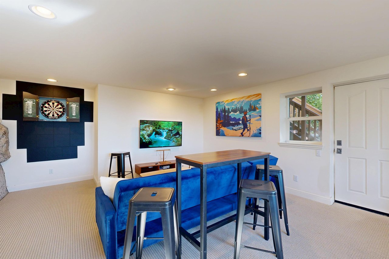 Smart TV, shuffleboard, darts, deck access, and a sofa pullout twin bed.