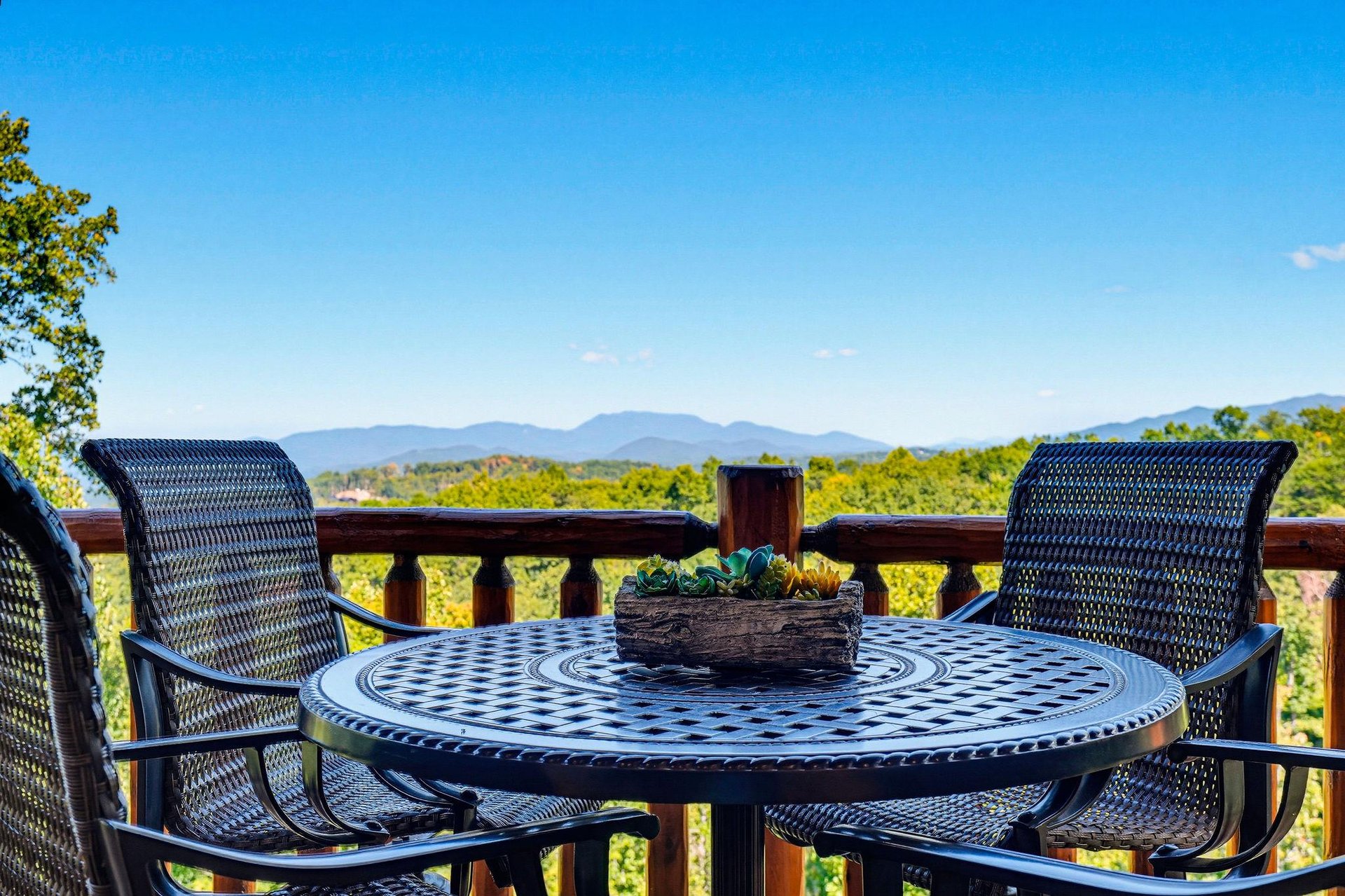 Sip your morning coffee at this inviting outdoor table, where sweeping mountain vistas and lush greenery create a peaceful backdrop for relaxation.