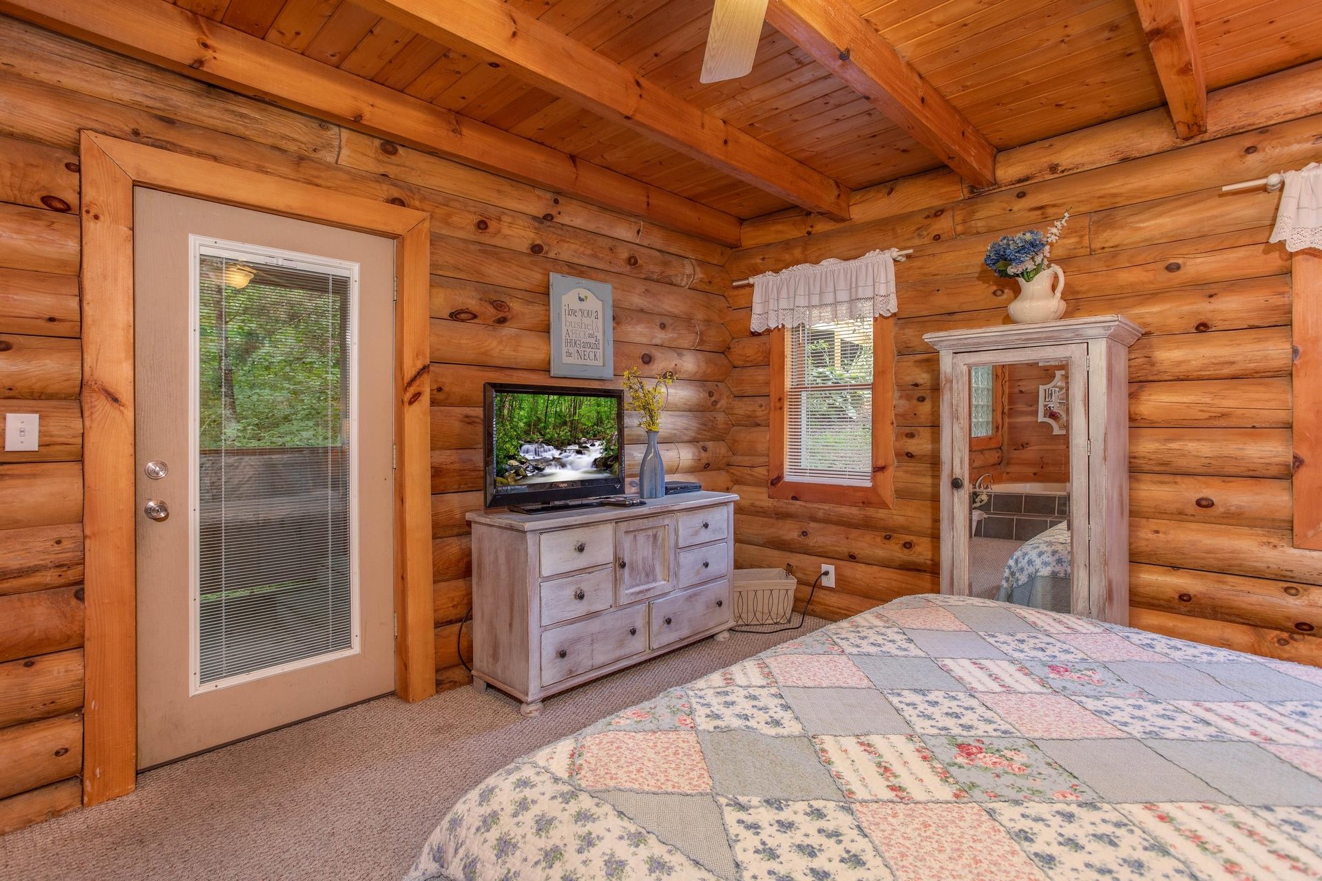 bedroom with television dresser and deck access at alpine something blue a 1 bedroom cabin rental located in pigeon forge