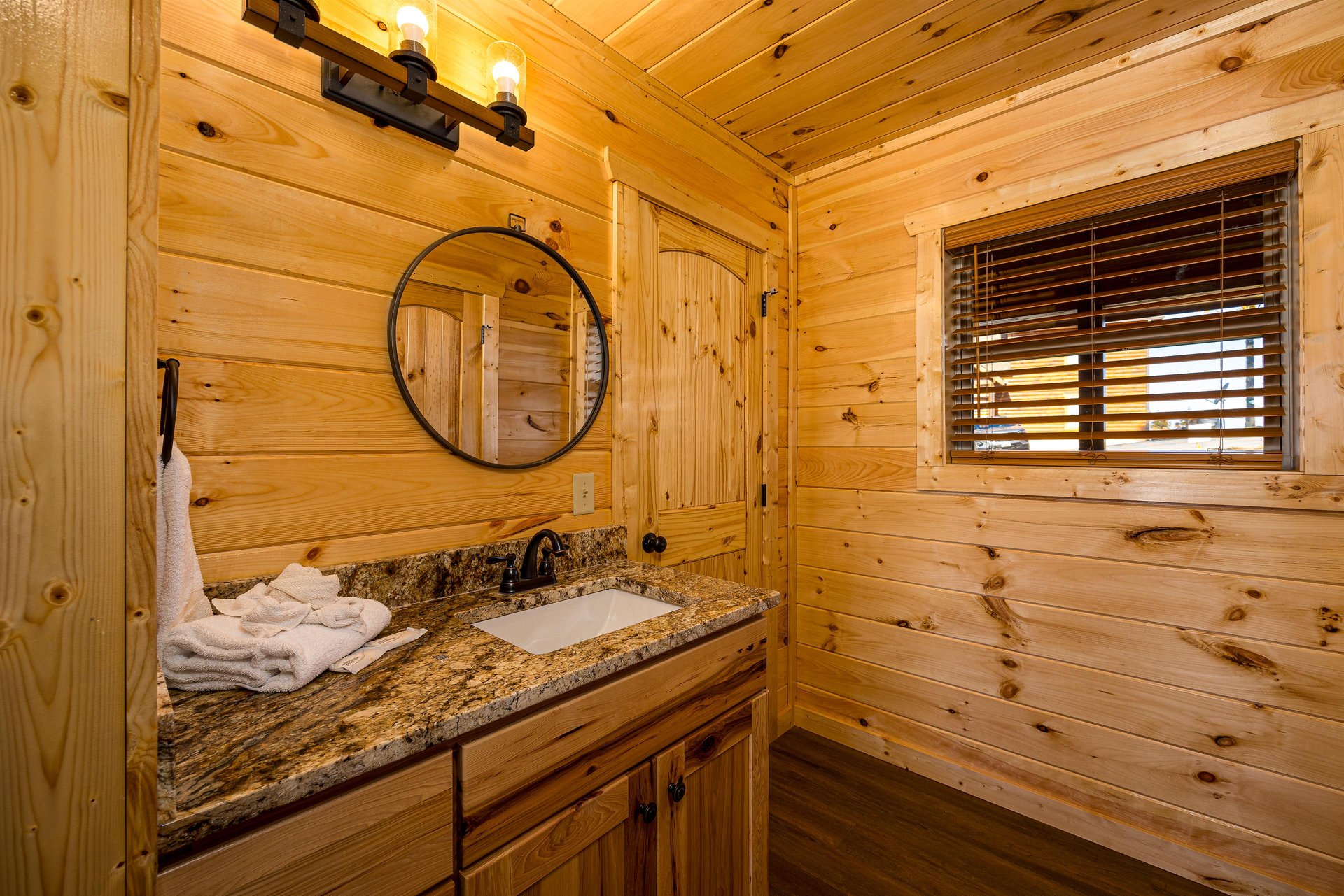 single vanity, round mirror, and natural light