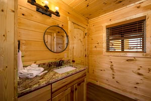 single vanity, round mirror, and natural light