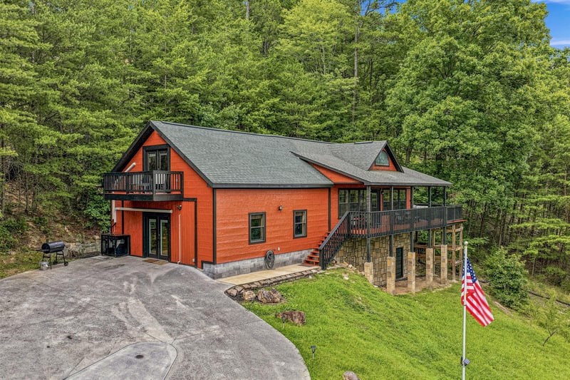 This striking mountain property sits nestled in lush forest, featuring multiple levels of deck space and ample parking, offering a scenic retreat with vibrant natural surroundings.