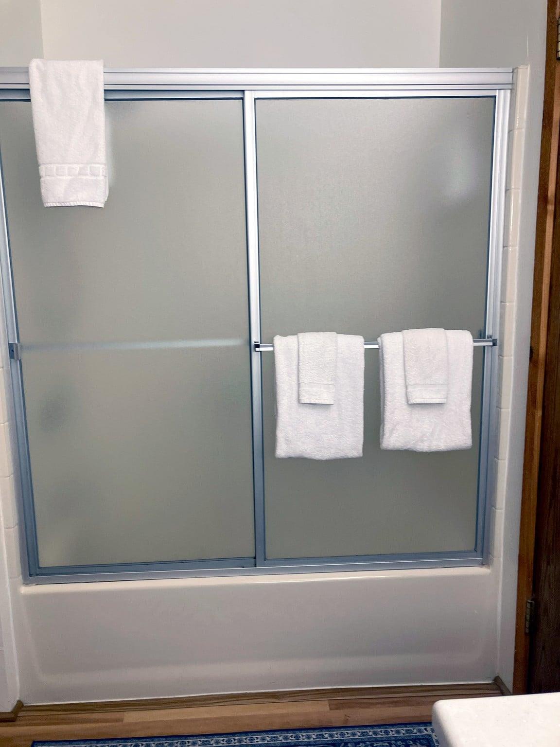 The upstairs bathrooms glassenclosed shower and tub, shared between the primary and second bedrooms.