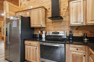 Your fully equipped cabin kitchen features sleek stainlesssteel appliances, warm wood cabinetry, and stylish granite countertops—perfect for whipping up morning coffee or a hearty family meal togethe
