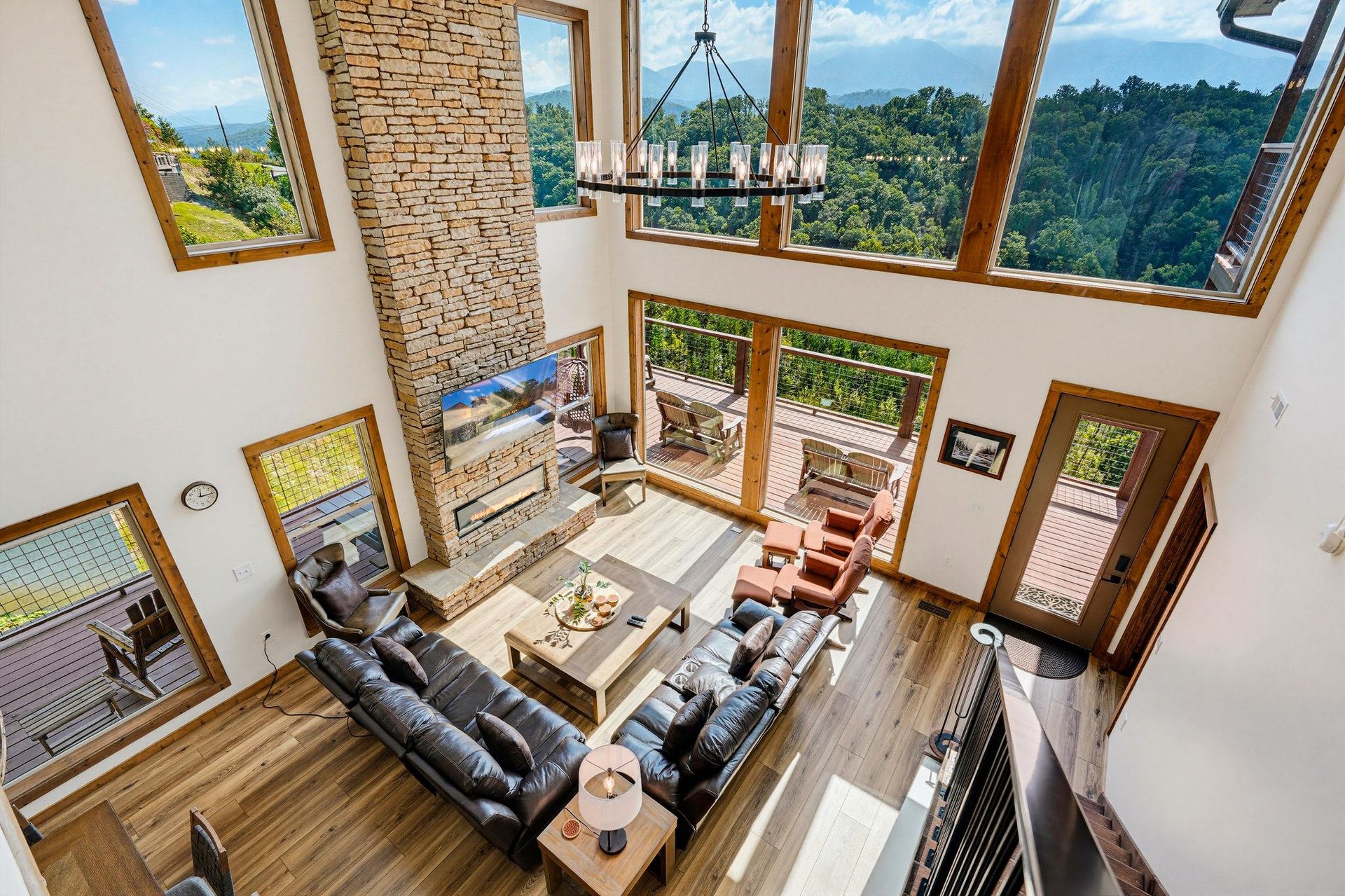 Expansive windows frame breathtaking mountain views in your openconcept living space, where vaulted ceilings and natural wood beams create an inviting, airy atmosphere perfect for gathering and relax