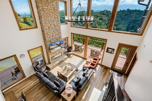 Expansive windows frame breathtaking mountain views in your openconcept living space, where vaulted ceilings and natural wood beams create an inviting, airy atmosphere perfect for gathering and relax