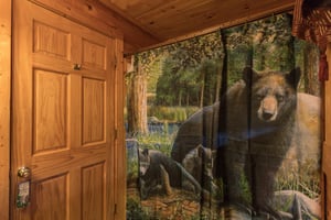 Bathroom with a tub and shower and black bear decor at Hibernation Station, a 3bedroom cabin rental located in Pigeon Forge