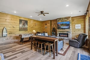Unwind in your rustic game room with cozy fireplace, foosball table, and mountain cabin charm for perfect evenings.