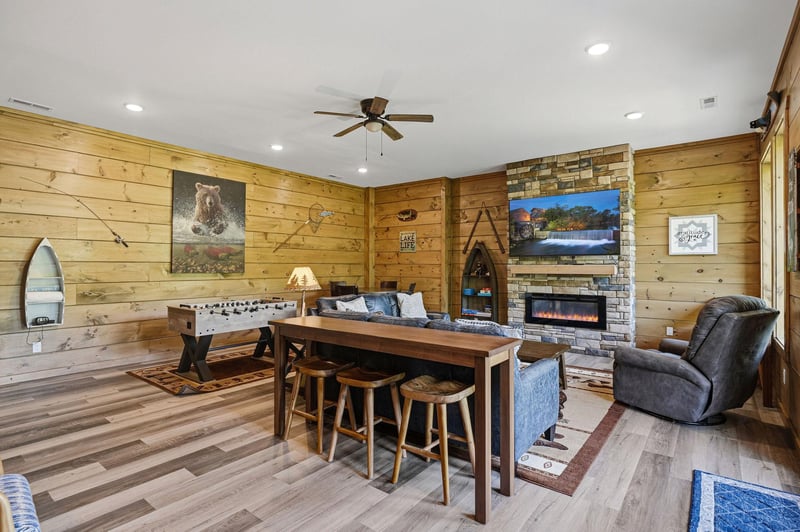 Unwind in your rustic game room with cozy fireplace, foosball table, and mountain cabin charm for perfect evenings.