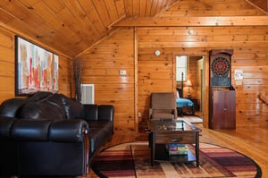 Unwind in your cozy living space with rich wood paneling, plush leather seating, and a dartboard for friendly competition. The cabins open layout invites you to relax and enjoy quality time together.