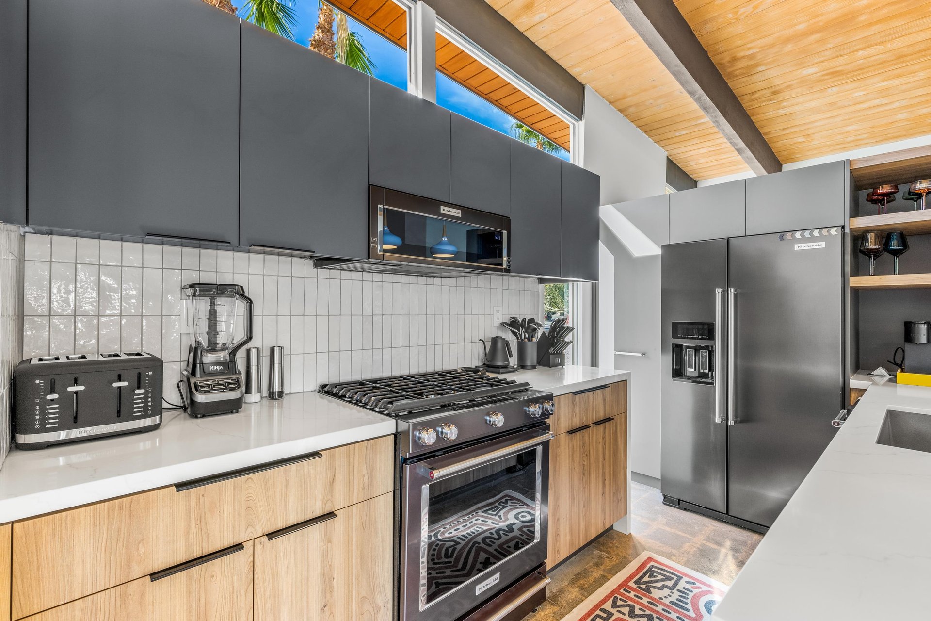 Your modern chefs kitchen features sleek appliances, gas range, and stunning woodbeam ceiling that creates a warm, sophisticated cooking experience.