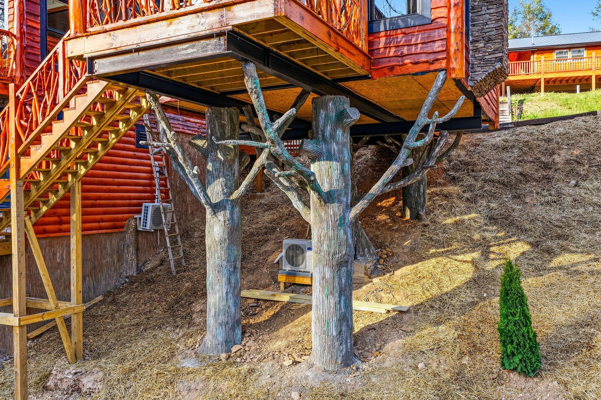 Mountain cabin property featuring rustic wooden construction with deck support structure and natural landscape surroundings.