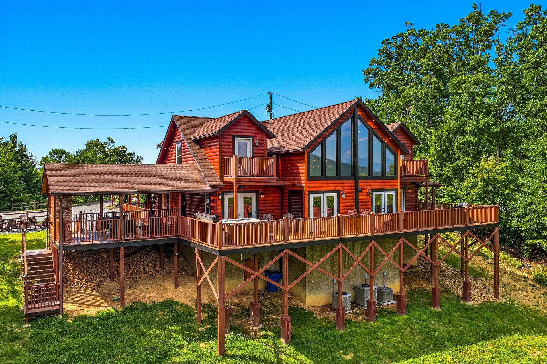 This spacious log cabin features multiple decks with scenic views, floortoceiling windows, and rustic charm nestled among lush trees—perfect for a peaceful mountain retreat.