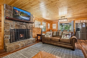 Sink into the leather sofa beside the stone fireplace and unwind in your cozy cabin retreat. Natural wood surrounds you while modern touches keep you comfortable.