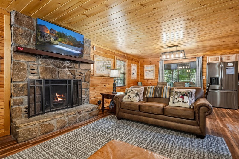 Sink into the leather sofa beside the stone fireplace and unwind in your cozy cabin retreat. Natural wood surrounds you while modern touches keep you comfortable.