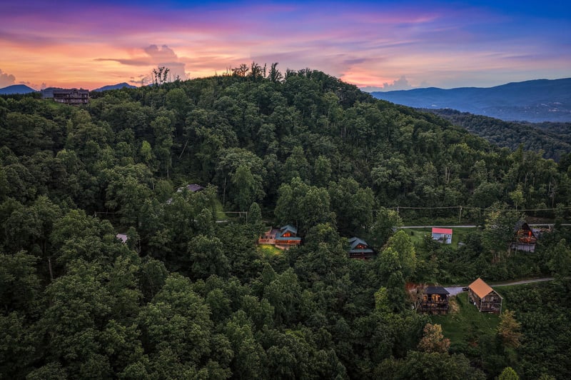 Nestled among lush forested mountains, this property captures the essence of a peaceful mountain retreat, with stunning evening skies painting the perfect backdrop for relaxation.