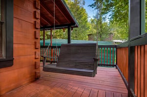 Your private deck with a soothing porch swing invites you to unwind surrounded by lush forest greenery and gentle mountain air.
