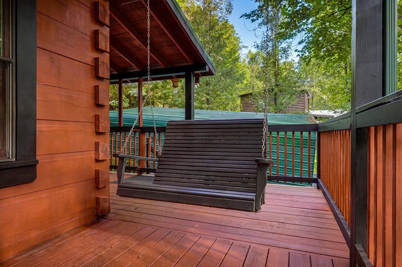 Your private deck with a soothing porch swing invites you to unwind surrounded by lush forest greenery and gentle mountain air.