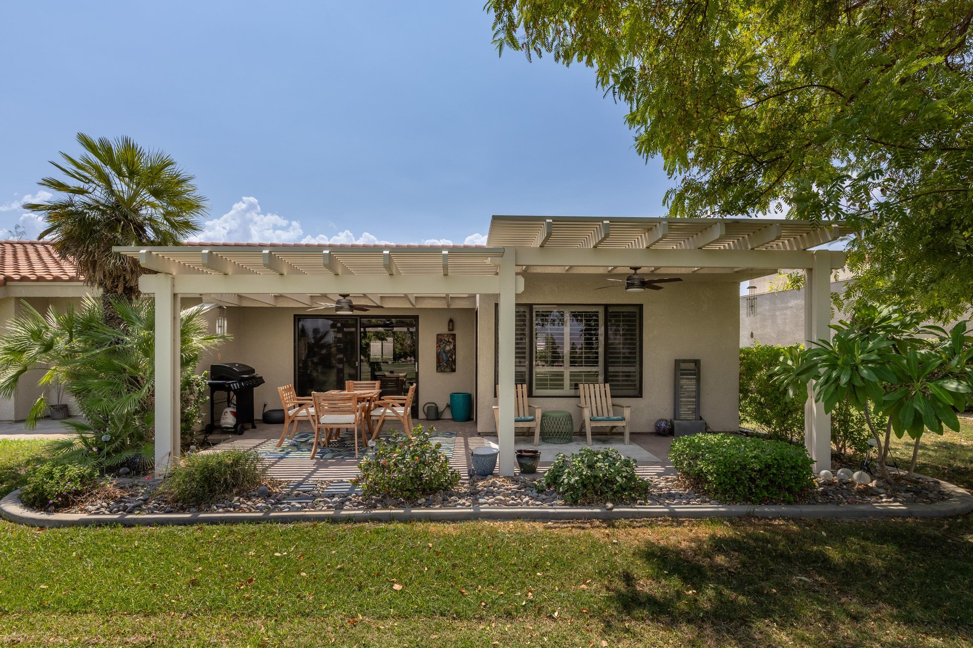 View of back patio including golf course views, outdoor dining area, and BBQ.