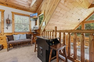 A cozy loft retreat with rustic log furnishings and vaulted wood ceilings creates your perfect hideaway. Relax on handcrafted seating or challenge friends to a game in this charming space flooded with
