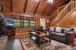 Unwind in your cozy cabin retreat with rustic wood beams, plush leather seating, and warm natural light streaming through. Your perfect mountain escape awaits.