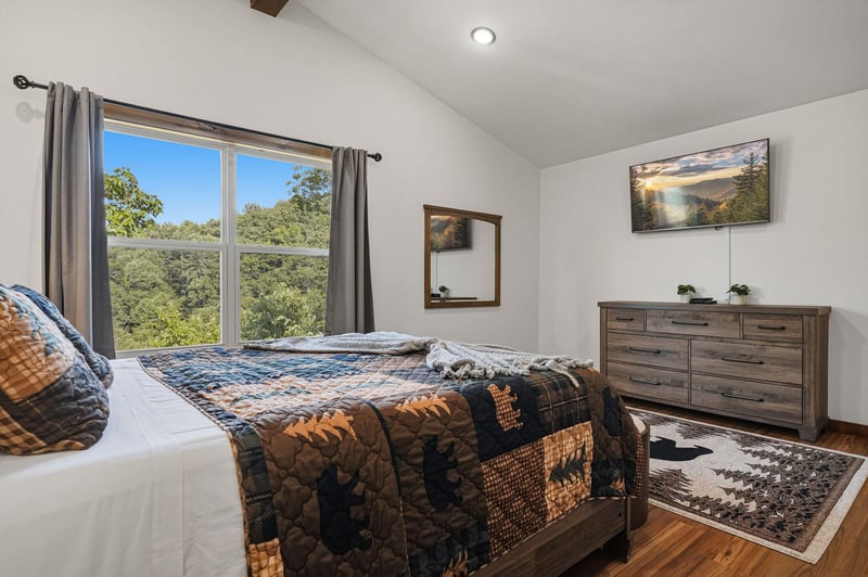 Wake up to peaceful views of lush treetops from your bright bedroom, where rustic charm meets modern comfort and natural light fills the space.