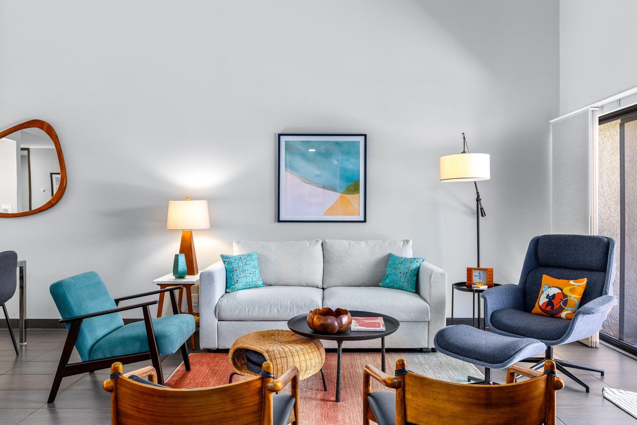 Living room has direct patio access, smart TV, ample seating, and openconcept living space.