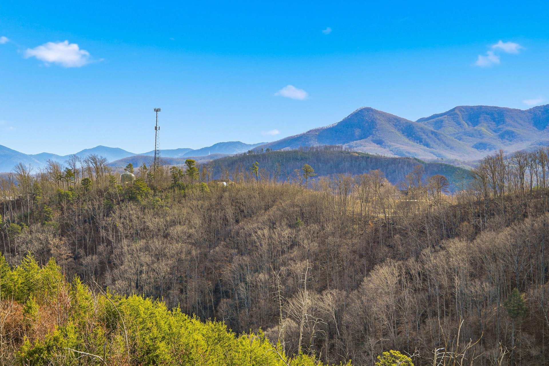 Stunning mountain views stretch across rolling peaks and forested valleys under brilliant blue skies in this scenic area.