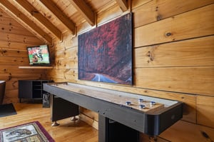 Game on Your private entertainment loft features a fullsize shuffleboard table beneath soaring vaulted wood ceilings, plus a TV for sports or movies—your perfect retreat after exploring the mountain