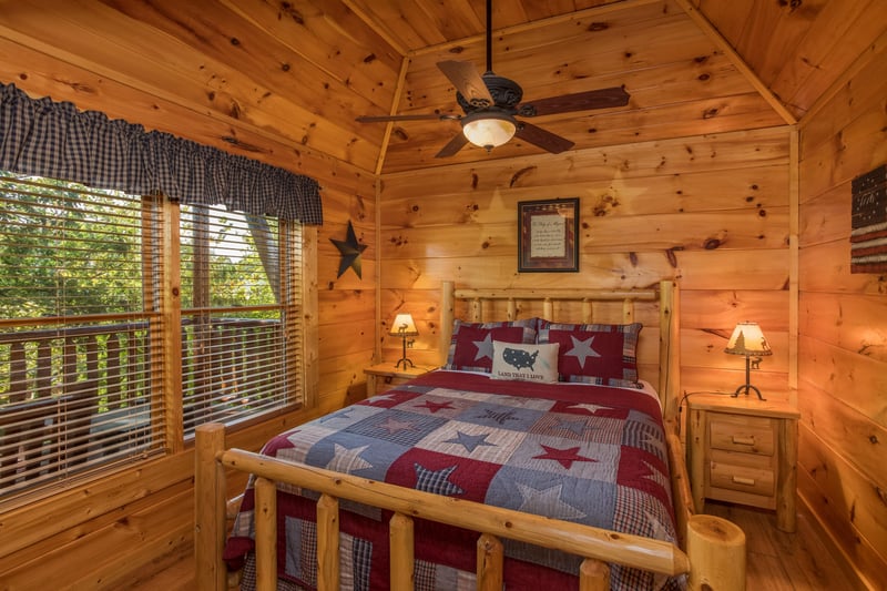 Bedroom with log bed, night stands, and lamps at Graceland, a 4bedroom cabin rental located in Pigeon Forge