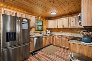 Your fully equipped kitchen features stainless appliances, gleaming granite counters, and rich wood cabinetry—perfect for whipping up meals in a warm, cabinstyle setting.