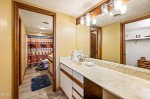 Step into your spacious bathroom featuring warm wood accents, elegant marble counters, and thoughtful amenities including fresh towels.