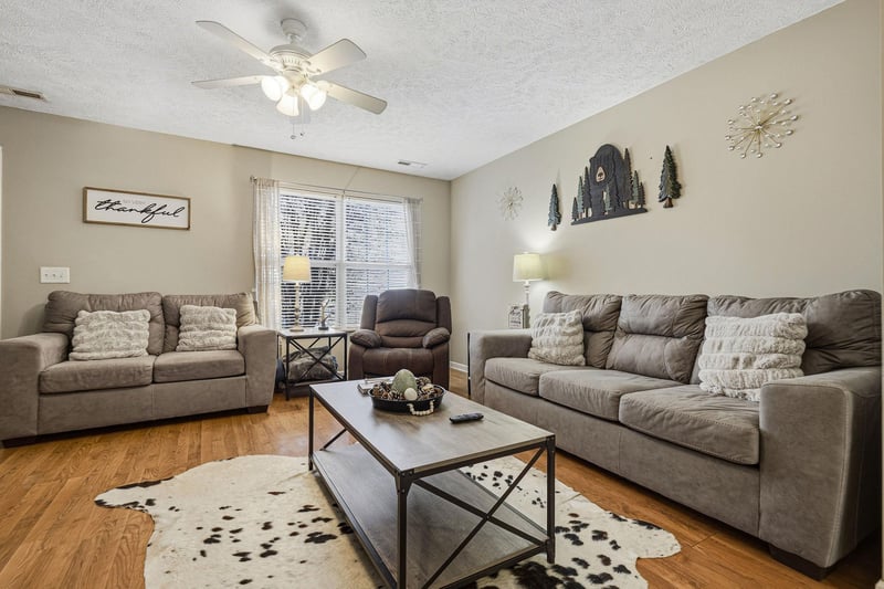 Sink into plush gray sofas and unwind in your spacious living room, complete with rustic decor and warm lighting for cozy evenings.