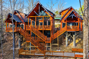 Stunning multilevel treehouse retreat with connecting bridges and decks, nestled among tall trees for an unforgettable forest escape.