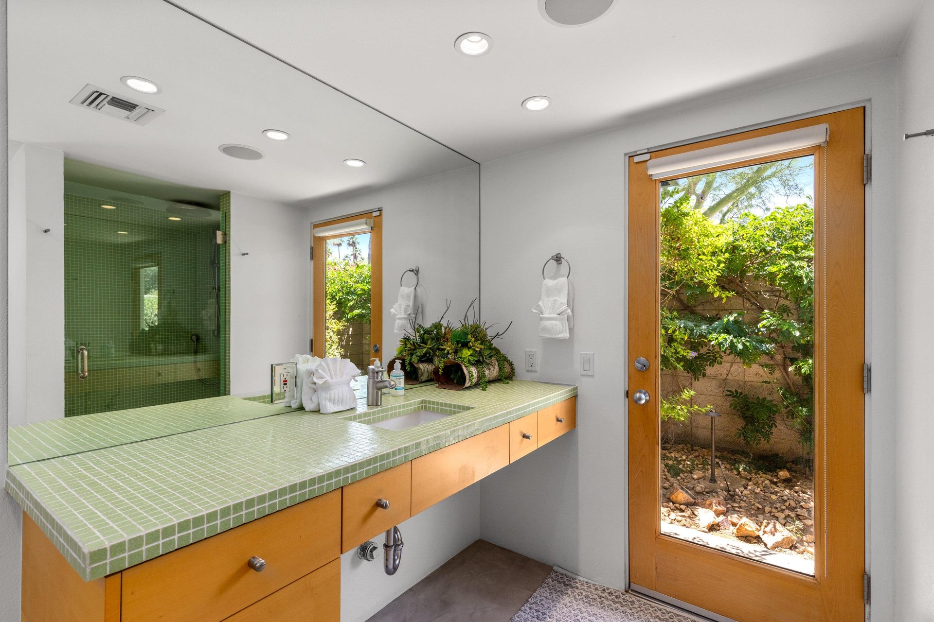 Ensuite bathroom with incredible tile, standalone shower, and door to the outside.