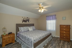 Bedroom with a king bed, dresser, and small dresser at Peace at the River, a 3 bedroom cabin rental located in Pigeon Forge