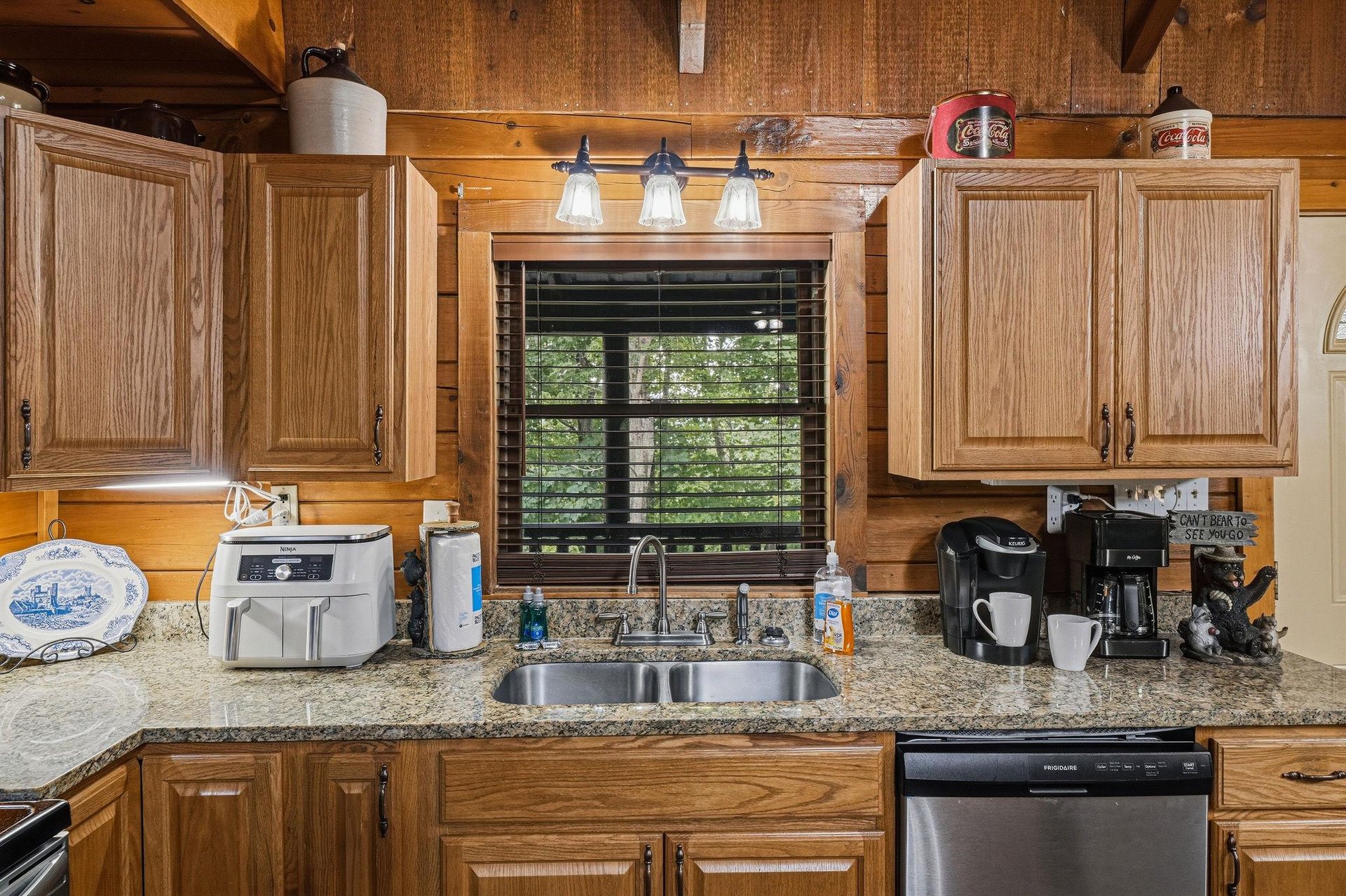 Step into a warm, cabinstyle kitchen with natural wood accents and modern conveniences—your coffee station awaits while you enjoy peaceful views of the surrounding greenery.