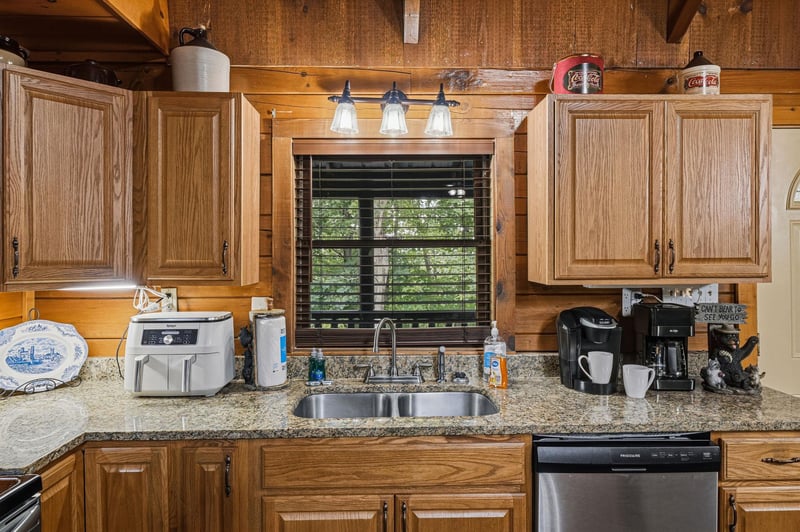 Step into a warm, cabinstyle kitchen with natural wood accents and modern conveniences—your coffee station awaits while you enjoy peaceful views of the surrounding greenery.