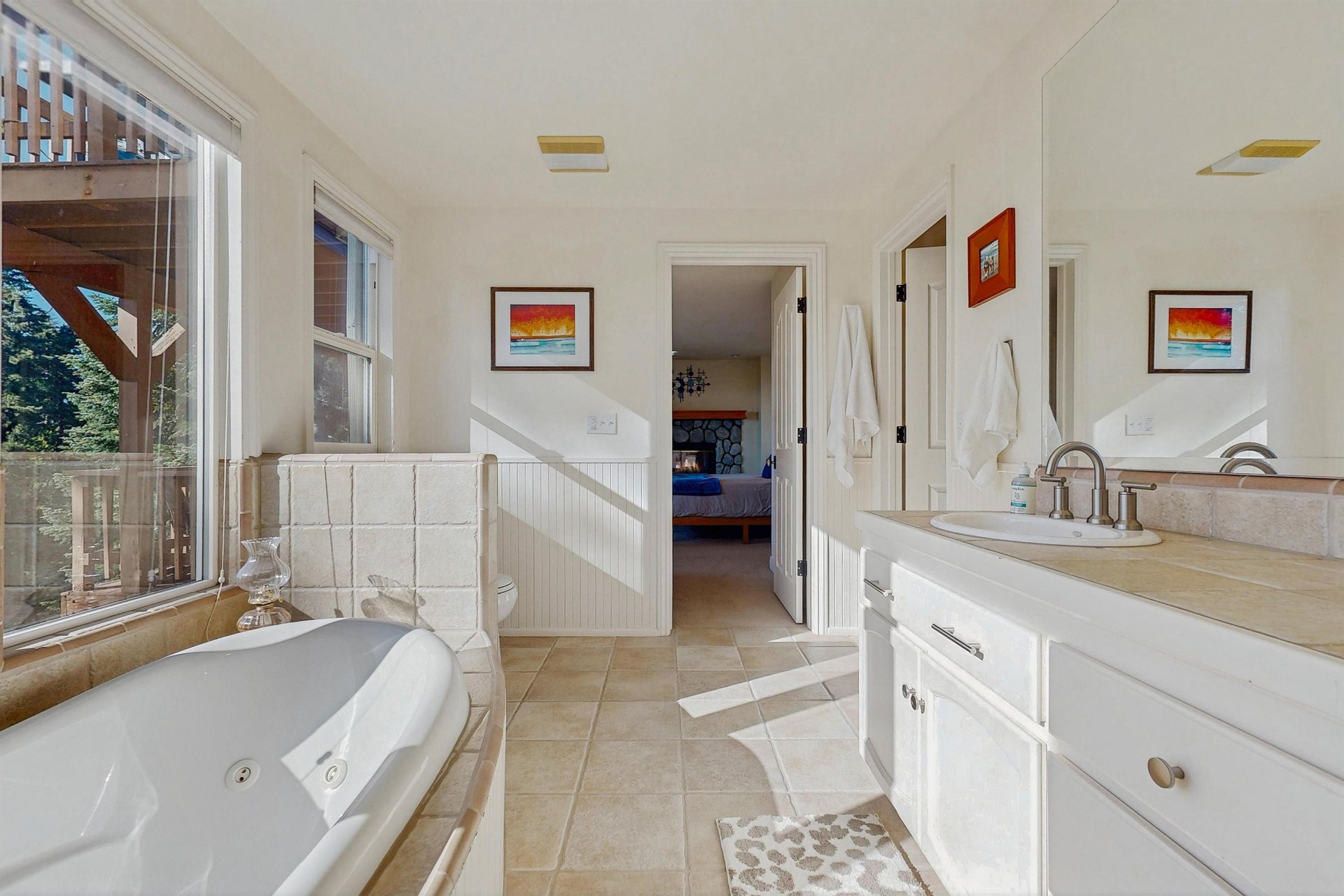 Ensuite bathroom equipped with a standalone jet tub, stand alone shower, dual vanity sink, and plenty of natural lighting.