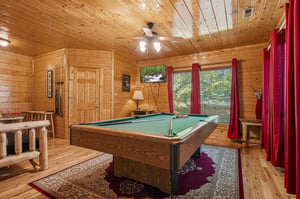 Challenge friends to a game on your private pool table in this rustic cabin retreat, where warm wood tones and natural light create the perfect atmosphere for fun.