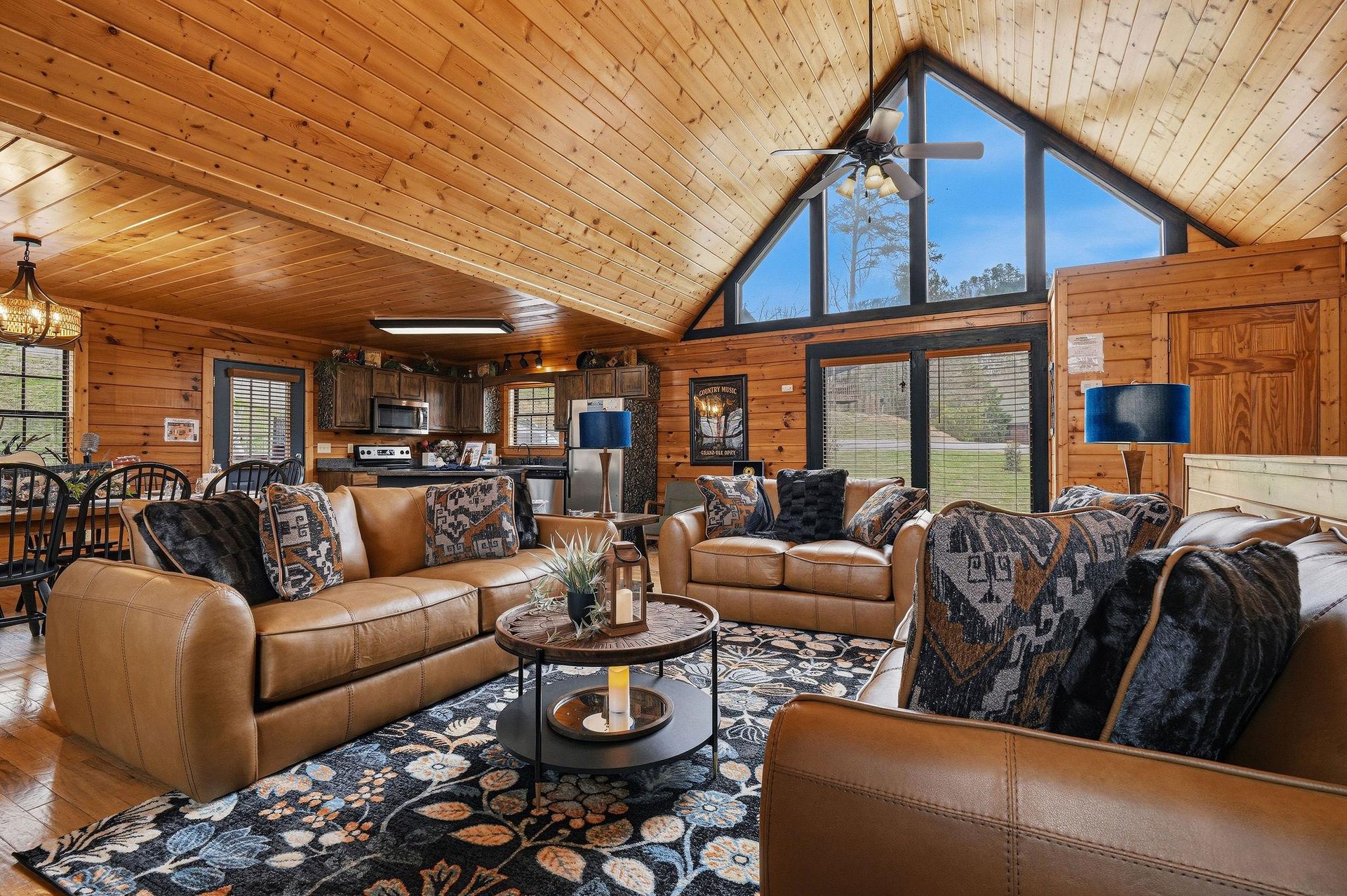 Relax in this stunning rustic living room where leather sofas invite you to unwind beneath soaring wood ceilings and dramatic windows.